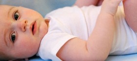 Diapered baby lying on back.