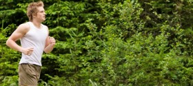 Young man running in forest.