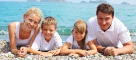 dreamstime_xs_19027480 young healthy family lying on ocean beach facing viewer